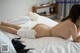 A woman laying on a bed in a white underwear.