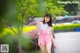 A woman in a white shirt and pink shorts walking down a sidewalk.