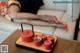 A woman laying on a couch next to a tray with cups of tea.