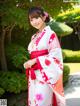 A woman in a red and white kimono posing for a picture.