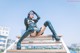 A woman sitting on top of a wooden bench.