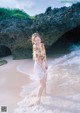 A woman standing in the water at the beach.