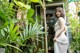 A woman in a white dress standing in front of a door.